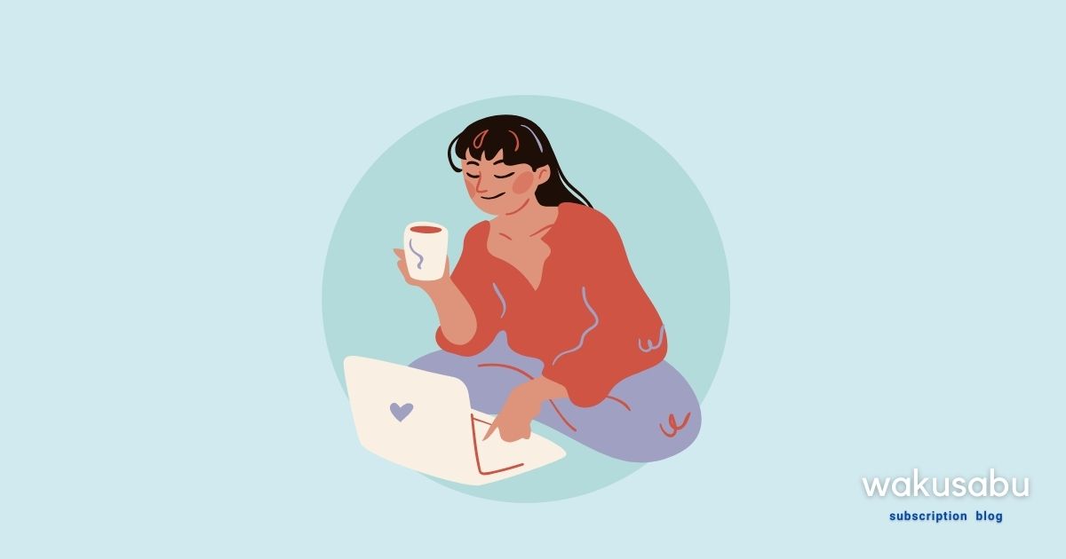 コーヒーを飲みながらパソコンを見る女性